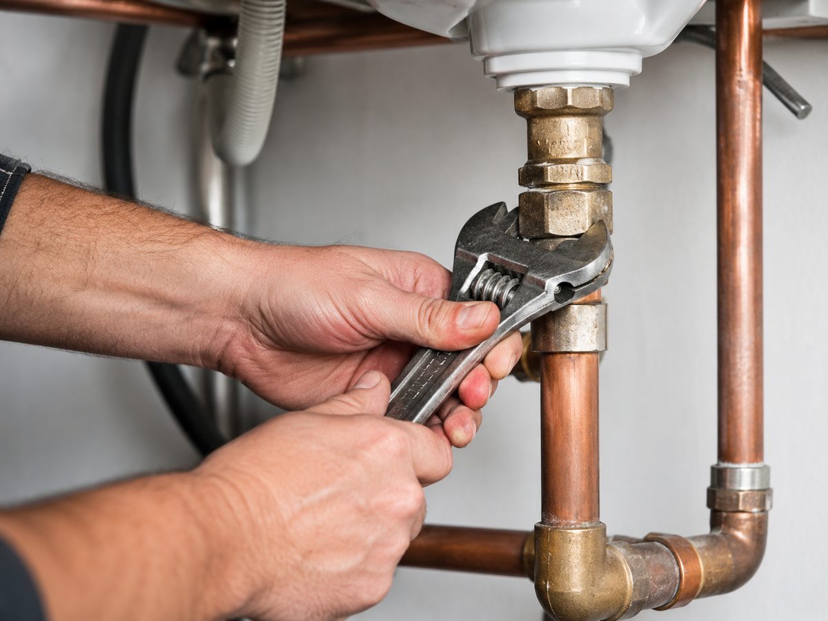 Plumber carrying out a general repair with a wrench